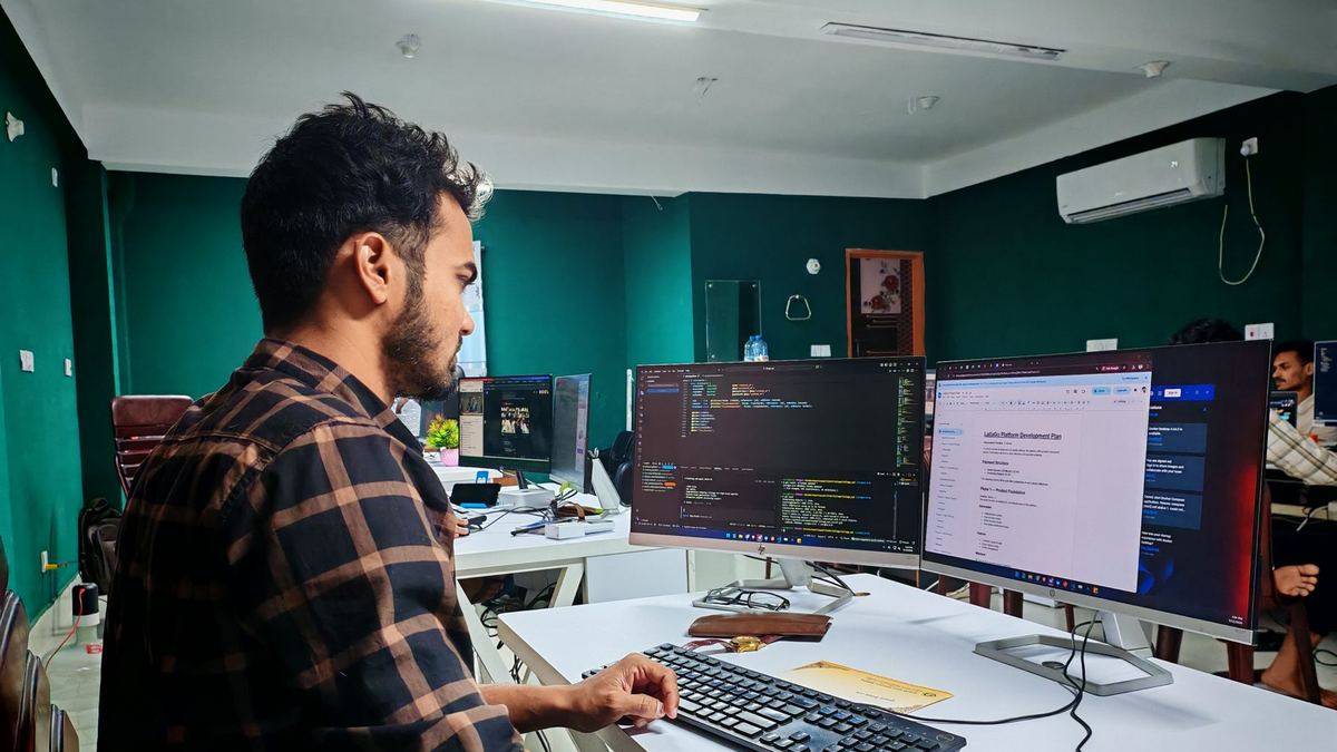 Software developer writing code at a multi-monitor workstation